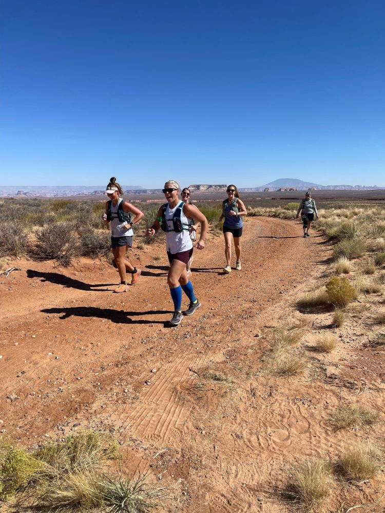 a group of people walking down a dirt road